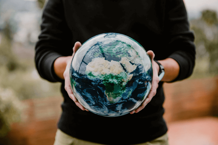 A person holding a glass globe