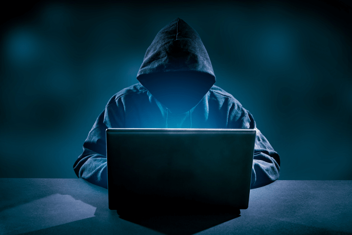A hacker wearing a hood that hides their face